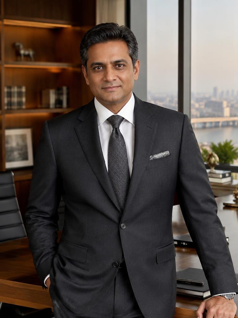 Fictional Indian businessman in an understated executive office
